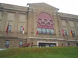 Photo of arena's two-storey brick exterior with the Olympic Rings above the entrance doors
