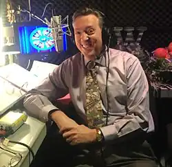 Jim Thornton, seated in a recording booth and wearing a headset