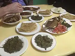 Image 4Fried tilapia fish and athola (beef stew) served with cooked kunde/mboga (cowpea leaves), managu/osuga (African nightshade), chapati, and ugali (from Culture of Kenya)