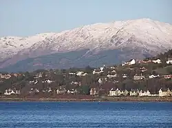 Houses in Kilcreggan west of the pier: the snowy hills in the background are on the other side of Loch Long.