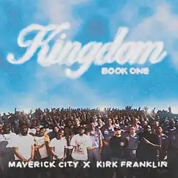 The album cover for Kingdom Book One is an overhead photo of Maverick City Music, Kirk Franklin, and the inmates of Everglades Correctional Institution and a relatively clear blue sky. The text on the image reads "Kingdom Book One" above the crowd, inscribed in a white font resembling clouds, while the artist credit "Maverick City x Kirk Franklin" is inscribed near the bottom of the image.