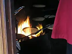 Long-handled skillets over a wood fire