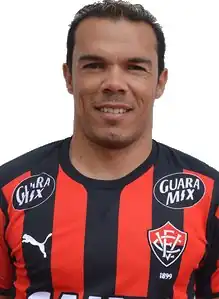 Caucasian male with dark hair wearing orange and black stripes of Esporte Clube Vitória