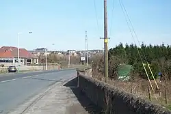 B981 towards Cowdenbeath, situated over dual carriageway (A92) just short of bridge over railway. Hill of Beath ahead