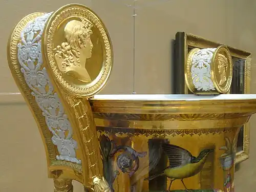 Neoclassical medallions on the handle of the Londonderry Vase, Sèvres porcelain , designed by Charles Percier, decoration designed by Alexandre-Theodore Brogniart, flowers and ornament painted by Gilbert Drouet, and birds painted by Christophe-Ferdinand Caron, 1813, hard-paste porcelain, polychrome enamels, gilding, and gilt bronze mounts, Art Institute of Chicago, US[12]