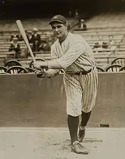 Medium shot of baseball player Lou Gehrig smiling and wearing a "NY" shirt and hat.