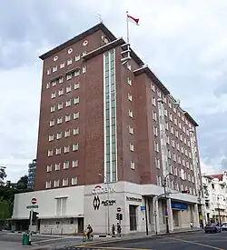the side of MacDonald House, the tall red brick building with white highlights and cladding at the ground floor.