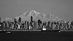 Black and white picture of the downtown Vancouver cityscape, a mountain in seen in the background.