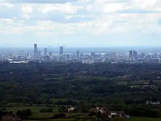 View of Manchester from Hartshead Pike, 8 miles (13 km) away with Fiddlers Ferry Power Station beyond, 27 miles (43 km) away.