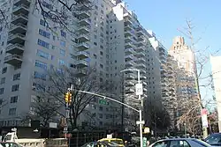 Manhattan House, a white brick building with glass balconies, as seen from Second Avenue and 66th Street. The apartment building is to the left, and there is a traffic light across the street.