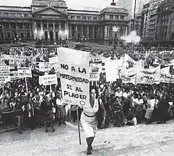 Image 10María Elena Oddone holding a banner, on International Women's Day in 1984 in Argentina. The banner says "No to motherhood, yes to pleasure" (from International Women's Day)