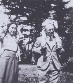 Black-and-white photo of Vidal and Bloch, each carrying one child on their shoulders