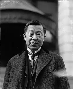 A black and white photo of a Japanese man in a suit.