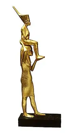 Gilded wooden statue showing Tutankhamun being carried by a goddess figure
