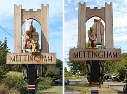 The original sign was erected in 1960 and included Mettingham castle on top and two owls in the spandrels. The new sign was erected and unveiled on 23rd June 2019 after seeing the deterioration of the old one. John Reeve, a local farmer and artist, who had painted the old sign for years, noticed the damage. Richard Lees, who had developed his skill as an expert wood carver and craftsman after his retirement from the army, generously offered to design and make a new sign. He had restored the sign in Geldeston, and created a new one in Ellingham. After much discussion it was decided to keep the castle for the new sign and include the owls as before. It was also decided to include a horse. There are a plenty of horses in Mettingham now, but there were even more working during the First and Second World Wars. The obvious model for the central figure was the Supreme Champion mare, Florence, belonging to Jayne Groom who can be seen in the centre of the sign holding the horse with a Farrier attending to the hooves. The Mettingham name is still carved down the post, with a carving of the church and what look like vegetables or trees below the name. The sign is located at the side of the B1062 close to the Tally Ho antiques centre, not far from the church.