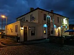 Large ornate white painted building illuminated at night with a dark blue sky