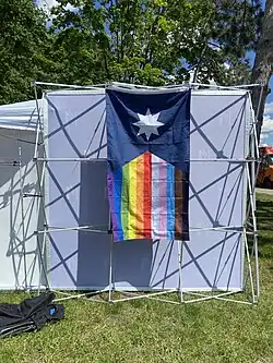 A Minnesota State Flag with a rainbow flag design on the field