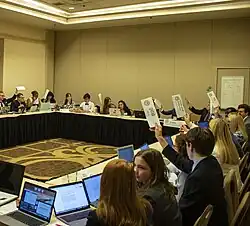Students raising country placards to vote on a motion