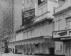 The Morosco Theatre as seen from an angle during the daytime. There are buildings on both sides.