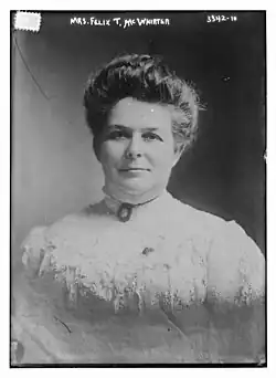 B&W portrait photo of a woman with her hair in an up-do, wearing a pale blouse.