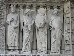 St. Denis (second from right) has angelic companions showing him polite concern; portal from Notre Dame de Paris (probably 19th century replacements)
