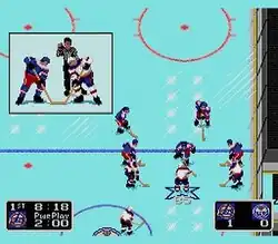 A square-shaped video game screenshot that is a digital representation of an ice hockey rink. A group of five hockey players in red and blue uniforms face off against an opposing team of four in white and blue uniforms. At the bottom left is a black box with text describing the game status: "1st" period, "8:18" time, and a "Power Play 2:00" timer. The score (1 to 0) is in a black box in the bottom right corner. A third light blue box appears in the upper left corner with a close up of the face-off: a member of each team has their hockey sticks on the ground with the referee behind them holding the puck above their sticks.