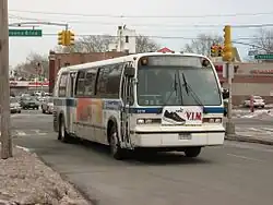The front of a Nova RTS bus in Q46 service on a large road in Kew Gardens Hills, Queens, during the winter