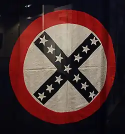 A black X in a white circle with stars running through the body of the X