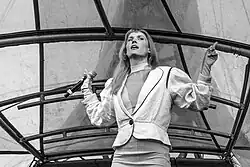 A black-and-white photograph of Danish singer-songwriter Oh Land performing live in 2023.