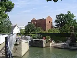 The derelict Osney Mill buildings off Mill Street to the west, with Osney Lock in the foreground.