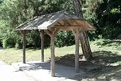 A rain shelter, made of concrete hand-sculpted to look like wood, a technique known as faux bois