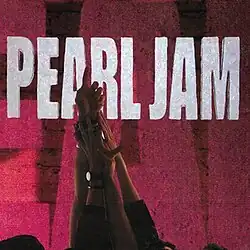 The band members have their hands raised up and holding another one's hand. In the background, a set of red-purple colored bricks with a cut-out of the name "Pearl Jam".