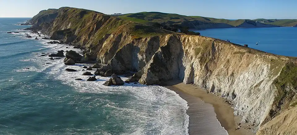 Steep cliffs by a rocky ocean and beach