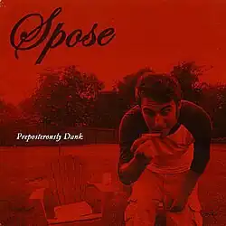 The red cover consists of a man outside next to a lawn chair, holding a blurred image of a blunt. The artist's logo appears on the top left corner and the album title is below it, colored in black and white respectively.