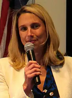 Simmons sitting on a chair for a mayoral debate