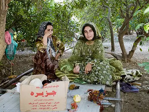 Qashqai nomad sisters, weaving a carpet on a floor loom. Near Firuzabad, Iran