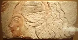 An Amarna relief depicting a woman undergoing a purification ritual, while the figure has been partially re-carved, the large earrings and style of wig are thought to be representative of Queen Kiya - on display at the Metropolitan Museum of Art