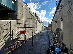 A ramp between a railway embankment and a single-story building