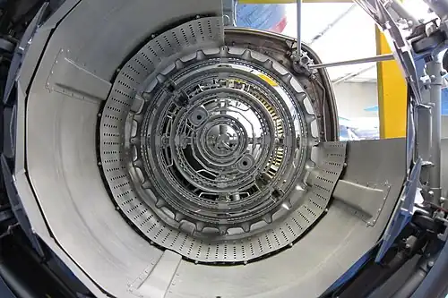 Adour afterburner rear view showing 4 concentric vapour gutters (flameholders) which supply fuel required for minimum boost, the majority of the fuel, known as fill fuel, for full boost comes from 4 concentric manifolds upstream of the gutters to produce flame across the whole afterburner except for cooling air along the duct surface. Also visible is the anti screech liner for preventing pressure fluctuations which can cause damage from overheating.[100]