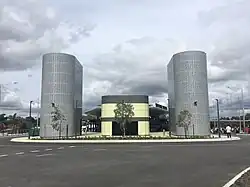 Green building with two large metal towers on either side
