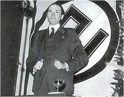 Lambrichts standing before a Volksverwering flag