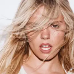 Rapp facing a camera with hair partially covering her right eye