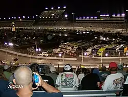 A photo of Richmond Raceway taken from the track's third turn. The photo shows the frontstretch and a majority of its grandstands.