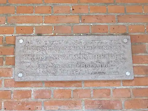 Stone plaque with inscription in the arcade.