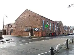 No. 97 Water Lane, originally a workshop forming part of the Round Foundry, built 1857–1877. Fenton, Murray and Jackson closed in 1843, this building built by Smith, Beacock and Tannett, machine tool manufacturers, who took over the site and renamed it Victorian Foundry.[7] No. 99 in the distance.