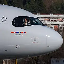 An SAS A320neo in regular livery showing the Star Alliance logo behind the cockpit windows.