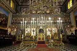Picture showing the iconostasis of the Church of San Nicolò flanked by candles.