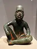Seated shaman in ritual pose-shaped pendant (Olmec); 9th-5th century BC; serpentine and cinnabar; height: 18.5 cm; Dallas Museum of Art (Dallas, Texas, US)[68]