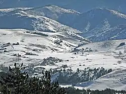 A landscape of the small town Semegnjevo with snow covered mountains