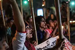 Protesters at night, chanting and holding torches